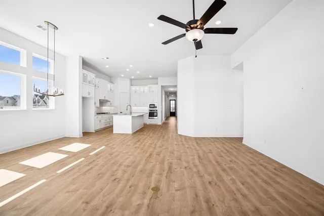 an empty room with a ceiling fan and carpet