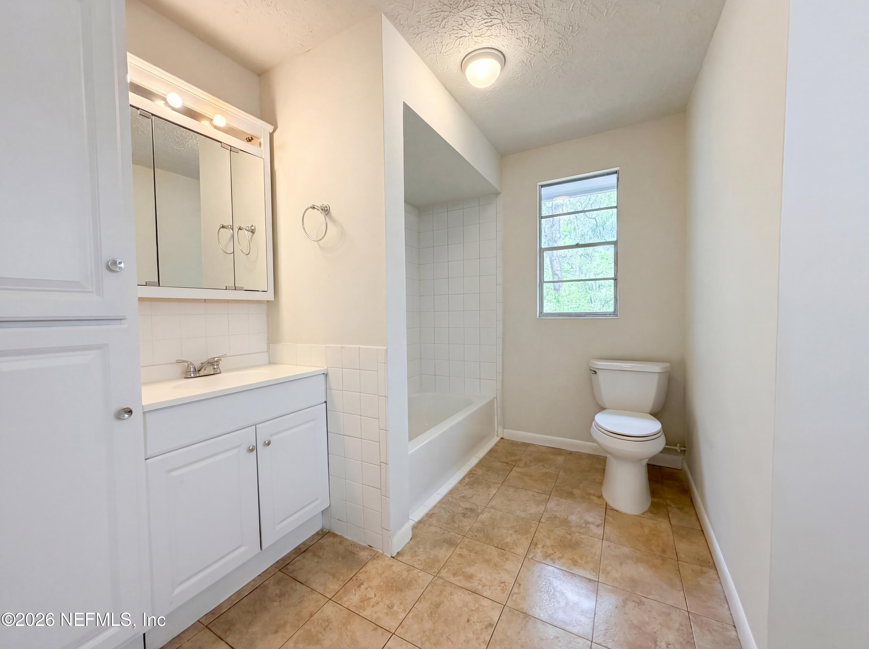 6917 Gatorbone Road Keystone Heights, FL 32656 - Photo 21 of 24 a bathroom with a toilet sink and mirror