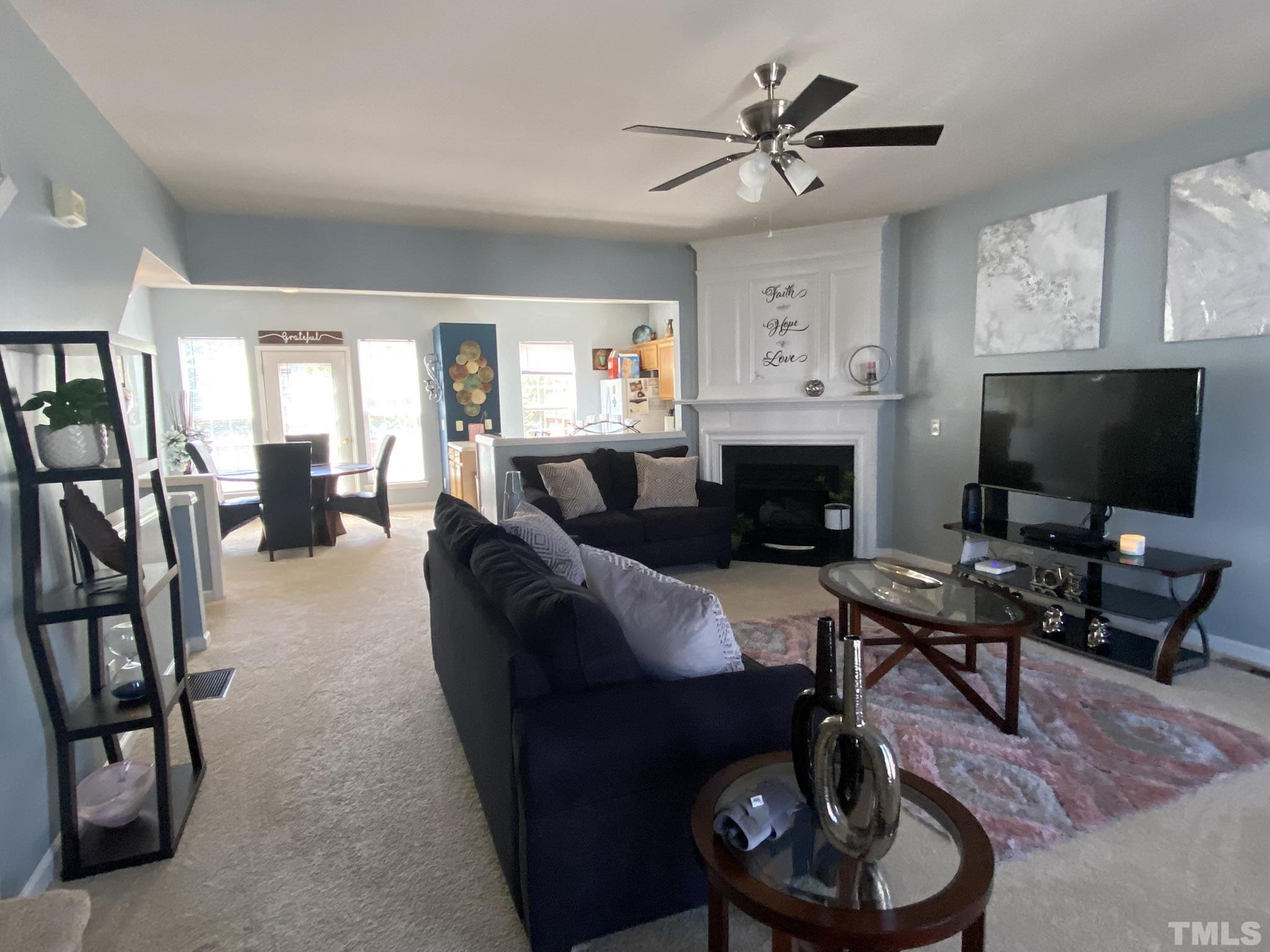 7251 Galon Glen Road Raleigh, NC 27613 - Photo 12 of 26 a living room with furniture a fireplace and a flat screen tv