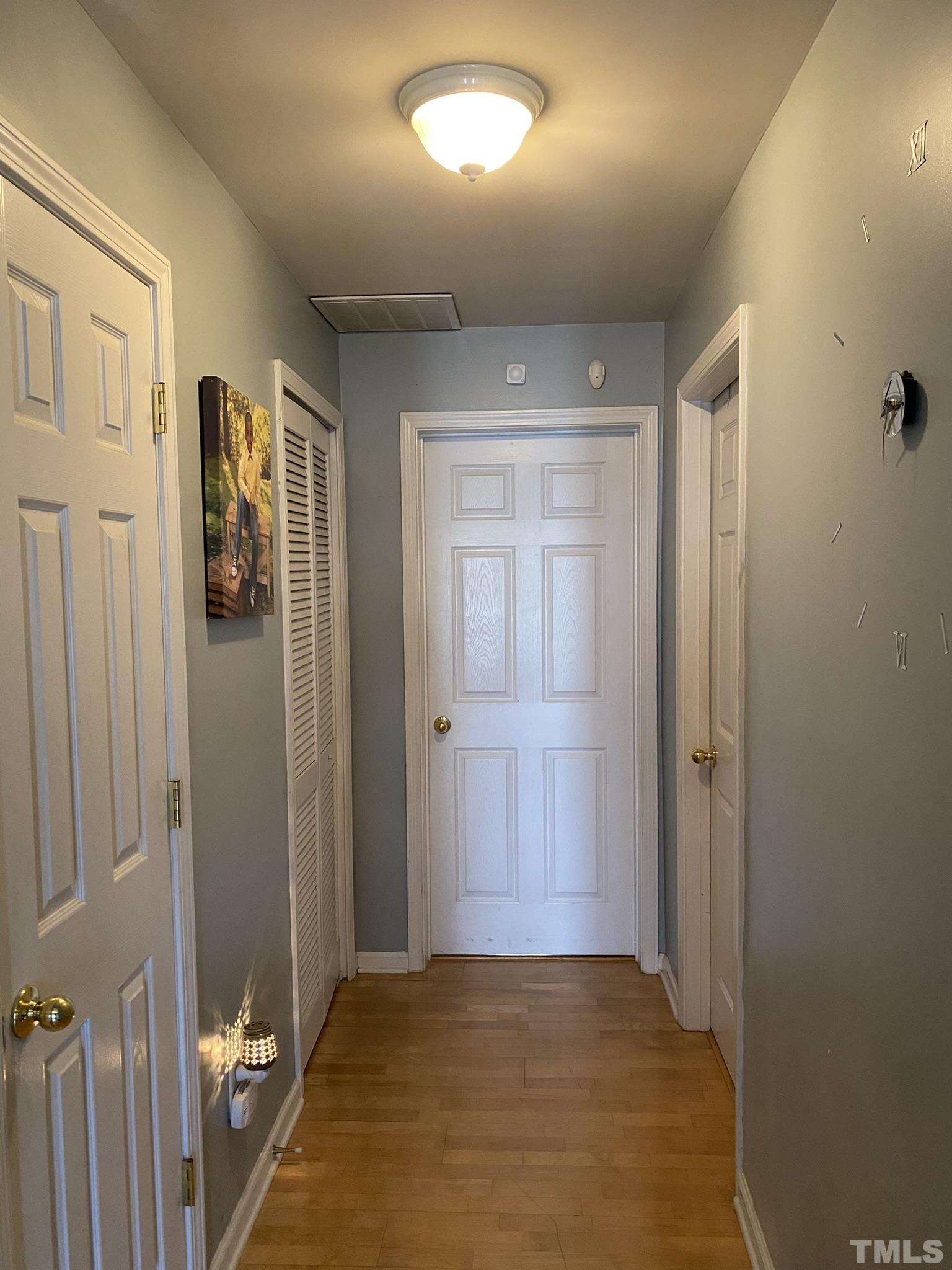 7251 Galon Glen Road Raleigh, NC 27613 - Photo 3 of 26 a view of a hallway with wooden floor and closet area