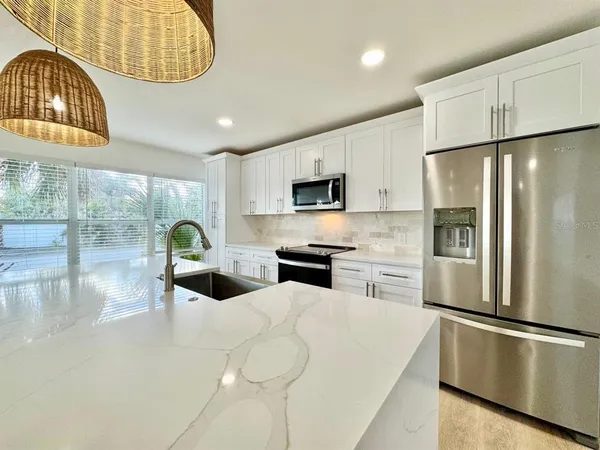 a kitchen with stainless steel appliances a refrigerator sink and cabinets