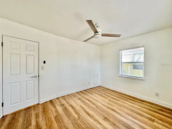 a view of empty room with wooden floor