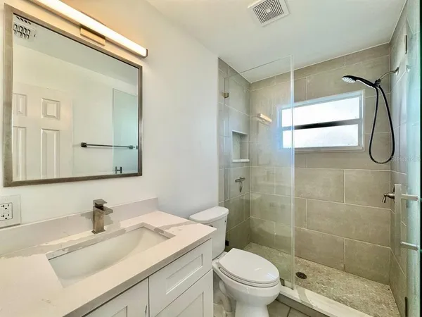 a bathroom with a granite countertop sink toilet and shower