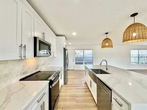 a kitchen with stainless steel appliances granite countertop a sink and a microwave