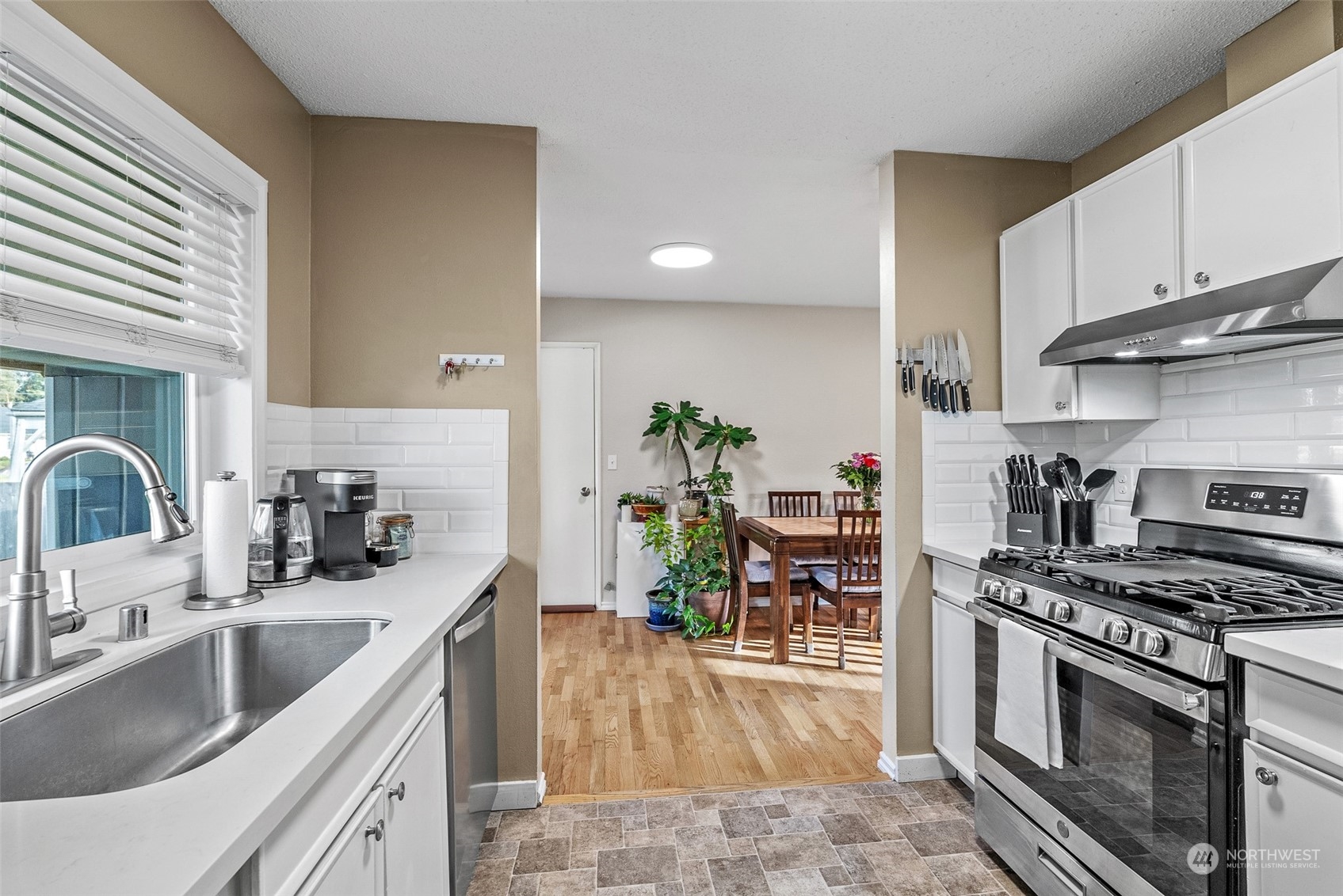 2313 Maple Lane Steilacoom, WA 98388 - Photo 16 of 40 a kitchen with granite countertop a sink a stove and cabinets