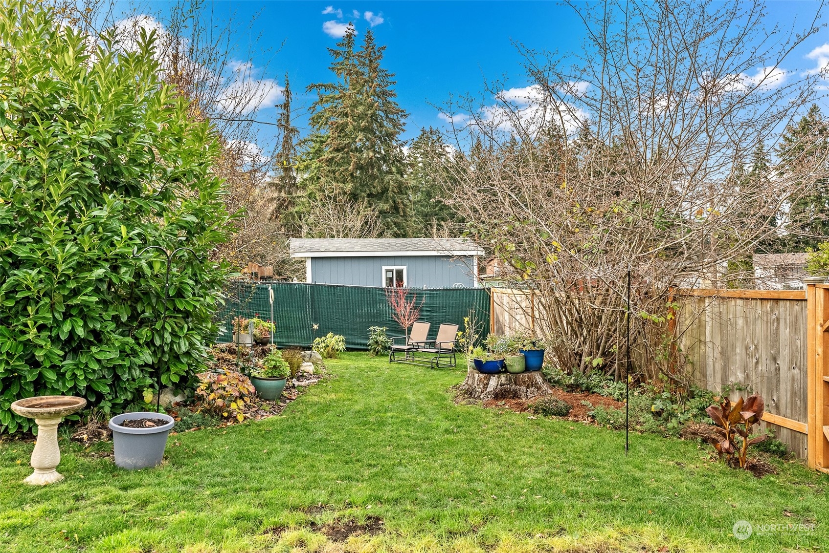 2313 Maple Lane Steilacoom, WA 98388 - Photo 35 of 40 a view of a backyard with table and chairs and potted plants and large trees