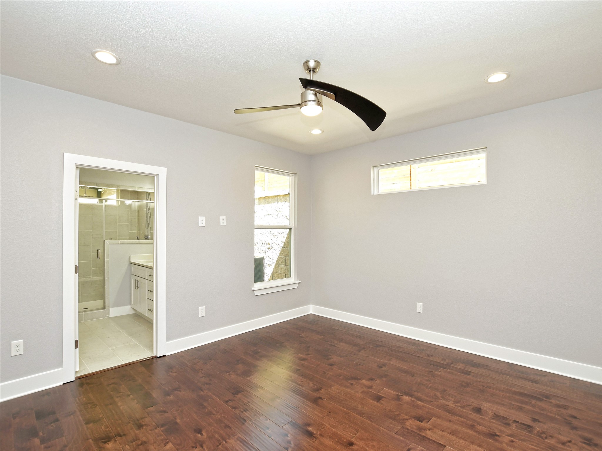 1130 Lott Avenue, Unit B Austin, TX 78721 - Photo 17 of 29 Unfurnished bedroom with dark wood-type flooring, ceiling fan, ensuite bathroom, and recessed lighting