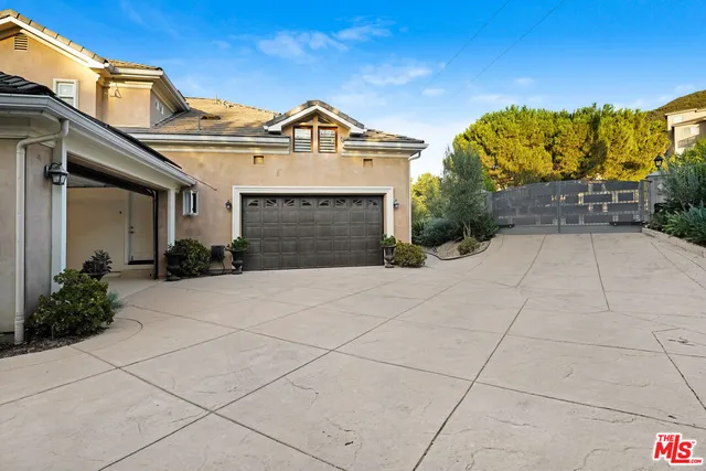 a view of a white house with large windows and open kitchen