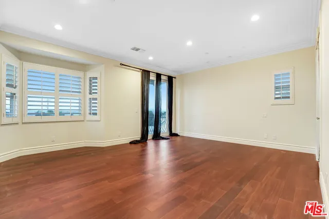 an empty room with wooden floor and mirror