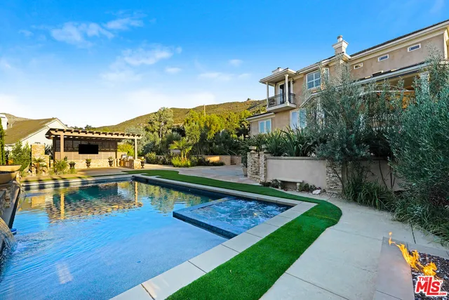 a view of swimming pool with a bench and trees in the background