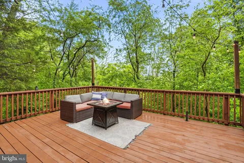 a balcony with wooden floor table and chairs