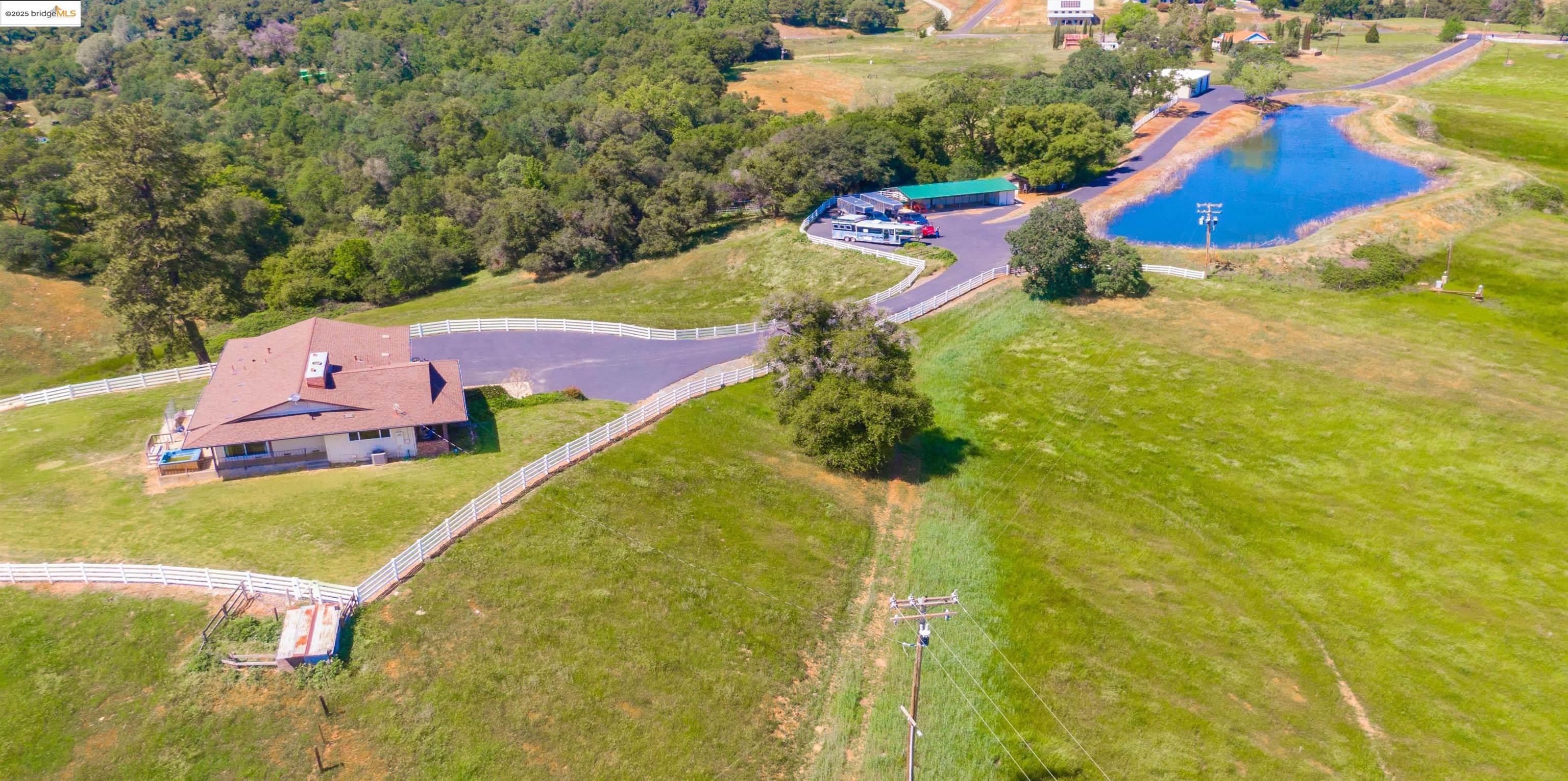 9325 Fraguero Road Sonora, CA 95370 - Photo 4 of 19 an aerial view of a house with swimming pool and red umbrella