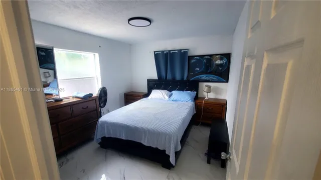 a bedroom with a bed and dresser with mirror
