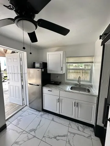 a kitchen with white cabinets and white appliances