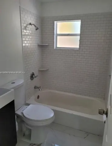 a bathroom with a toilet a sink and bathtub