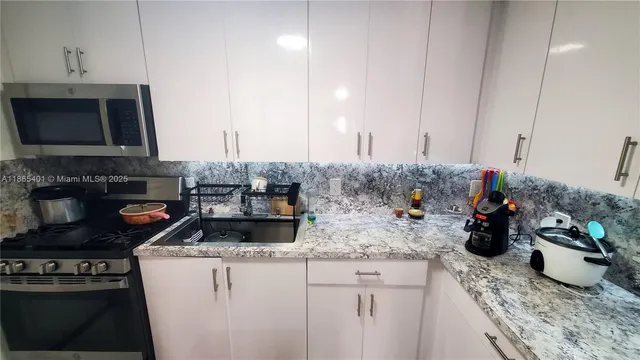 a kitchen with sink a microwave and cabinets