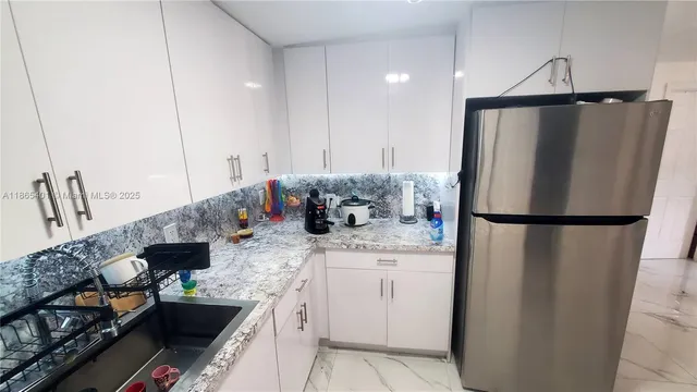 a kitchen with stainless steel appliances granite countertop a refrigerator and a sink