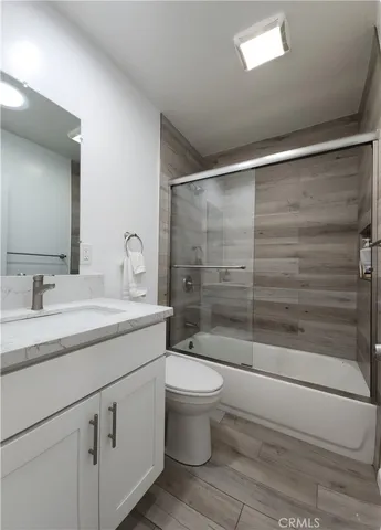 a bathroom with a shower sink vanity mirror and toilet
