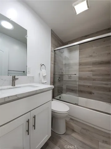 a bathroom with a shower sink vanity mirror and toilet
