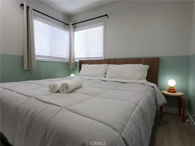 a bedroom with a bed and a lamp next to a window