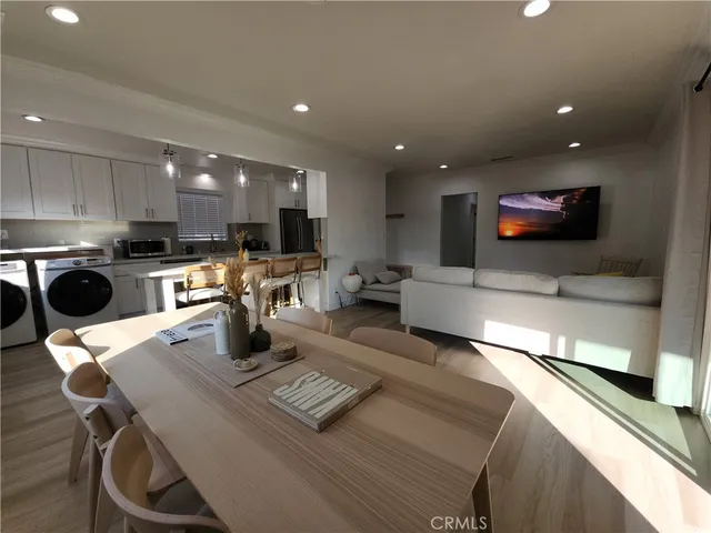 a kitchen with a table chairs refrigerator and microwave