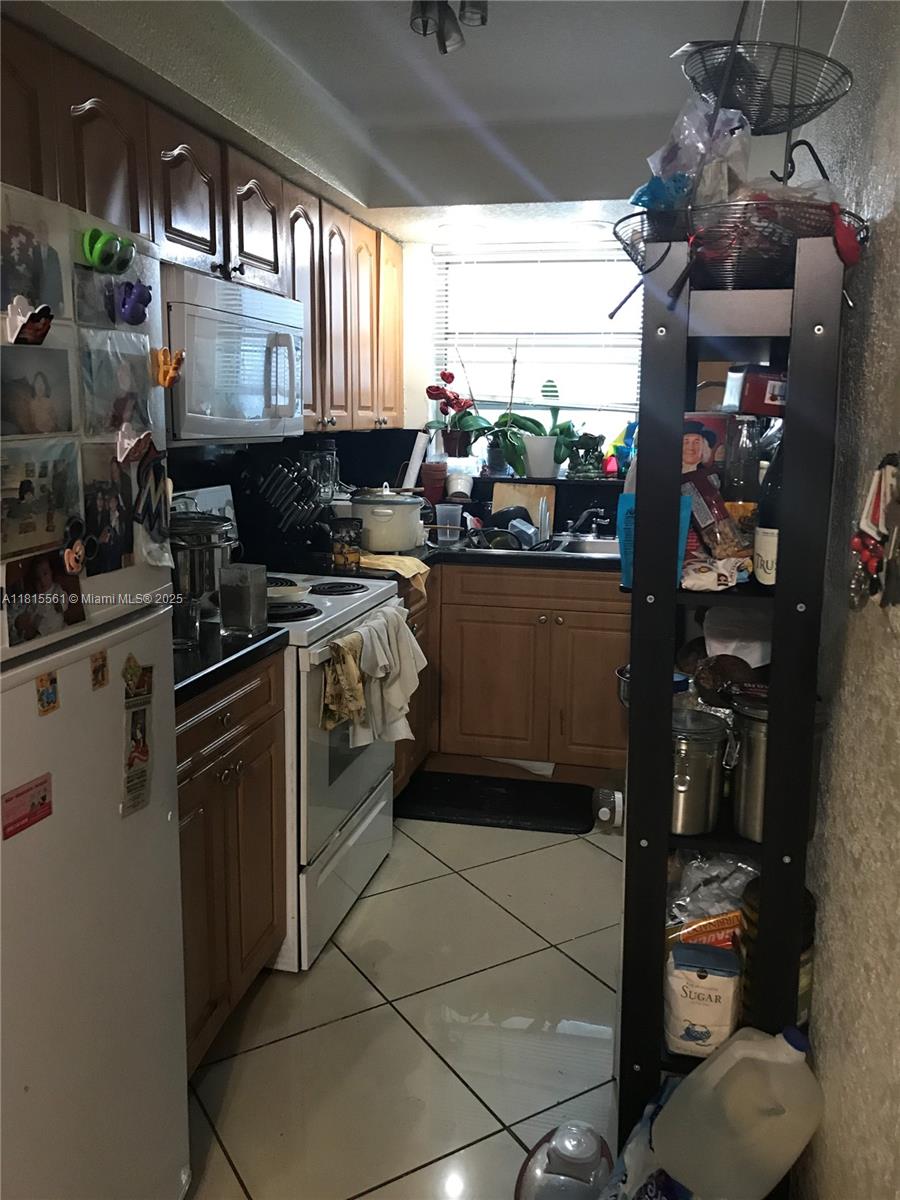 Glenvar Heights Miami, FL 33143 - Photo 10 of 10 a kitchen with stainless steel appliances granite countertop a stove a sink and a refrigerator