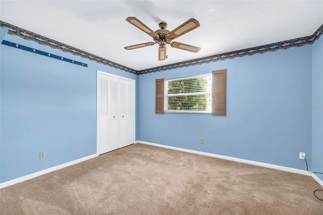 a view of an empty room with a ceiling fan