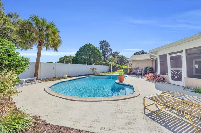 a swimming pool with outdoor seating and yard