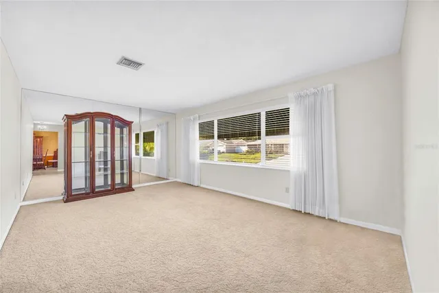 an empty room with furniture and floor to ceiling window