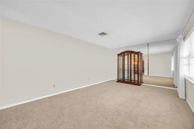 an empty room with windows and ceiling fan
