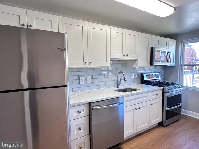 a kitchen with stainless steel appliances a refrigerator sink and cabinets