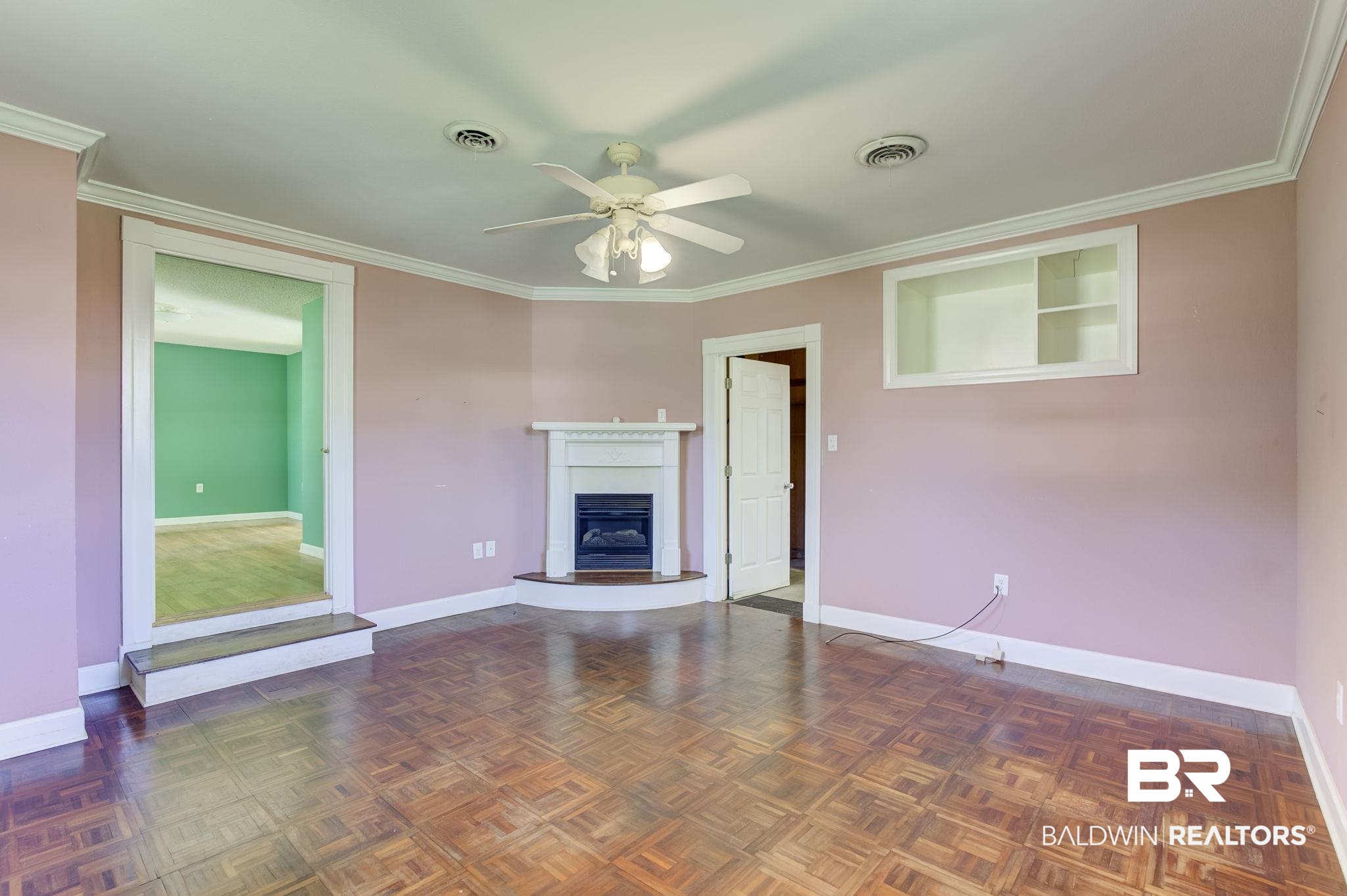 606 East Myrtle Avenue Foley, AL 36535 - Photo 5 of 24 Unfurnished living room featuring ceiling fan, crown molding, and dark parquet floors
