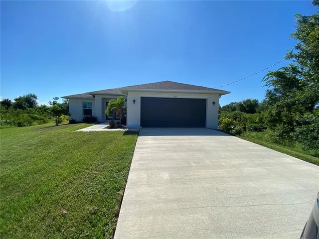 a front view of house with yard and trees in the background