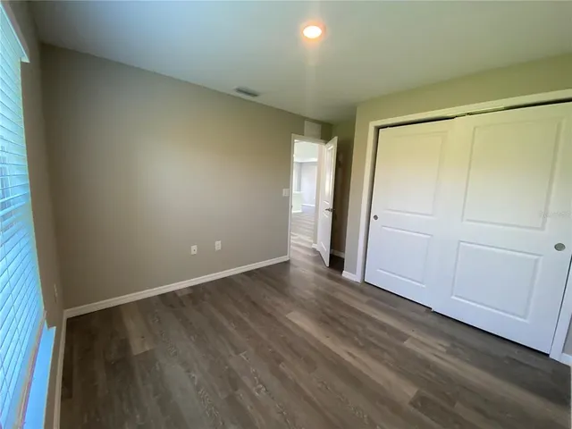 an empty room with wooden floor and closet