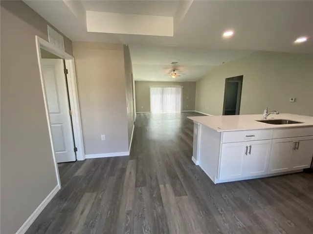 a hallway view with stainless steel appliances wooden floor and chair