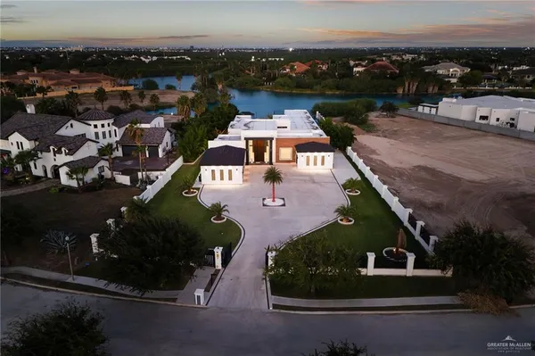 an aerial view of a house with a garden and lake view