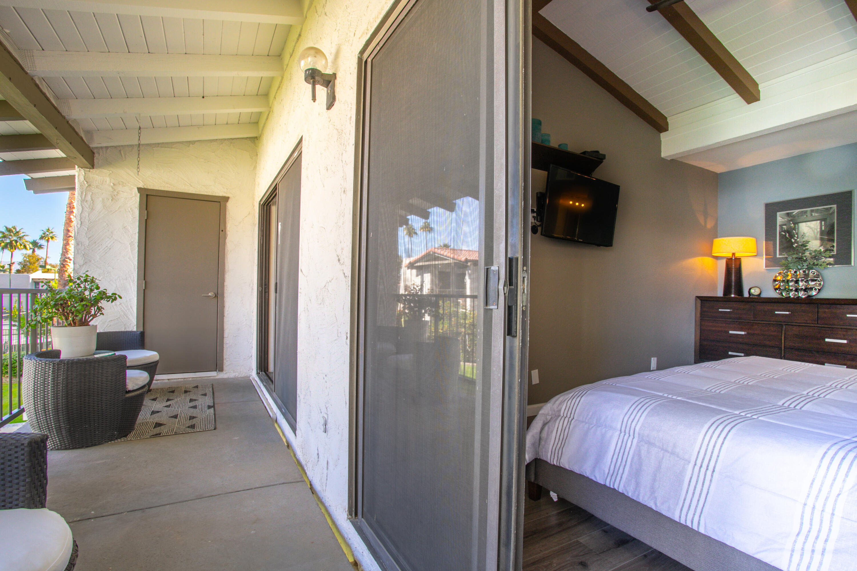 1050 Ramon Road, Unit 128 Palm Springs, CA 92264 - Photo 19 of 35 a bedroom with a bed and a potted plant