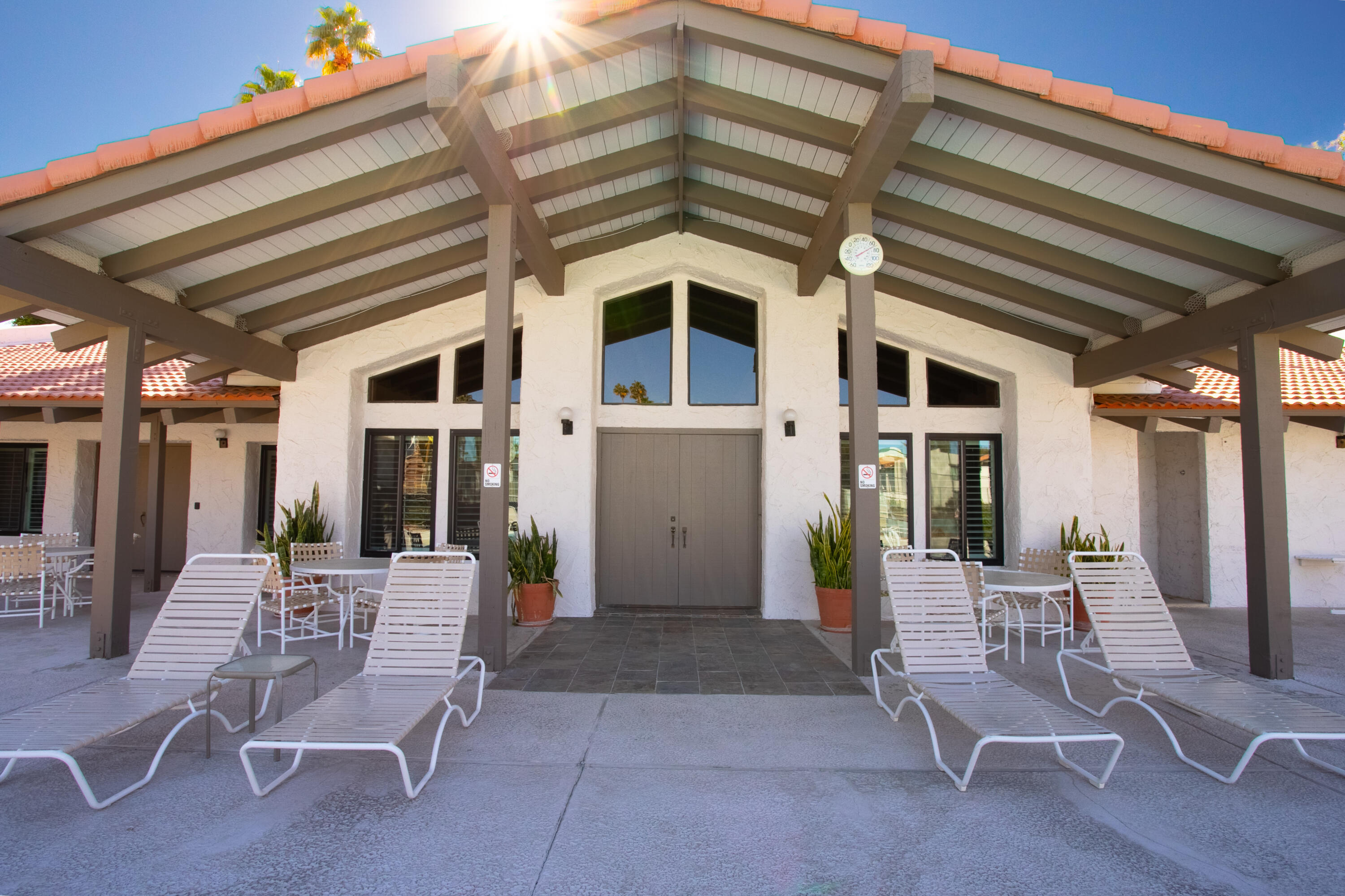 1050 Ramon Road, Unit 128 Palm Springs, CA 92264 - Photo 30 of 35 a view of a patio with a table and chairs and potted plants