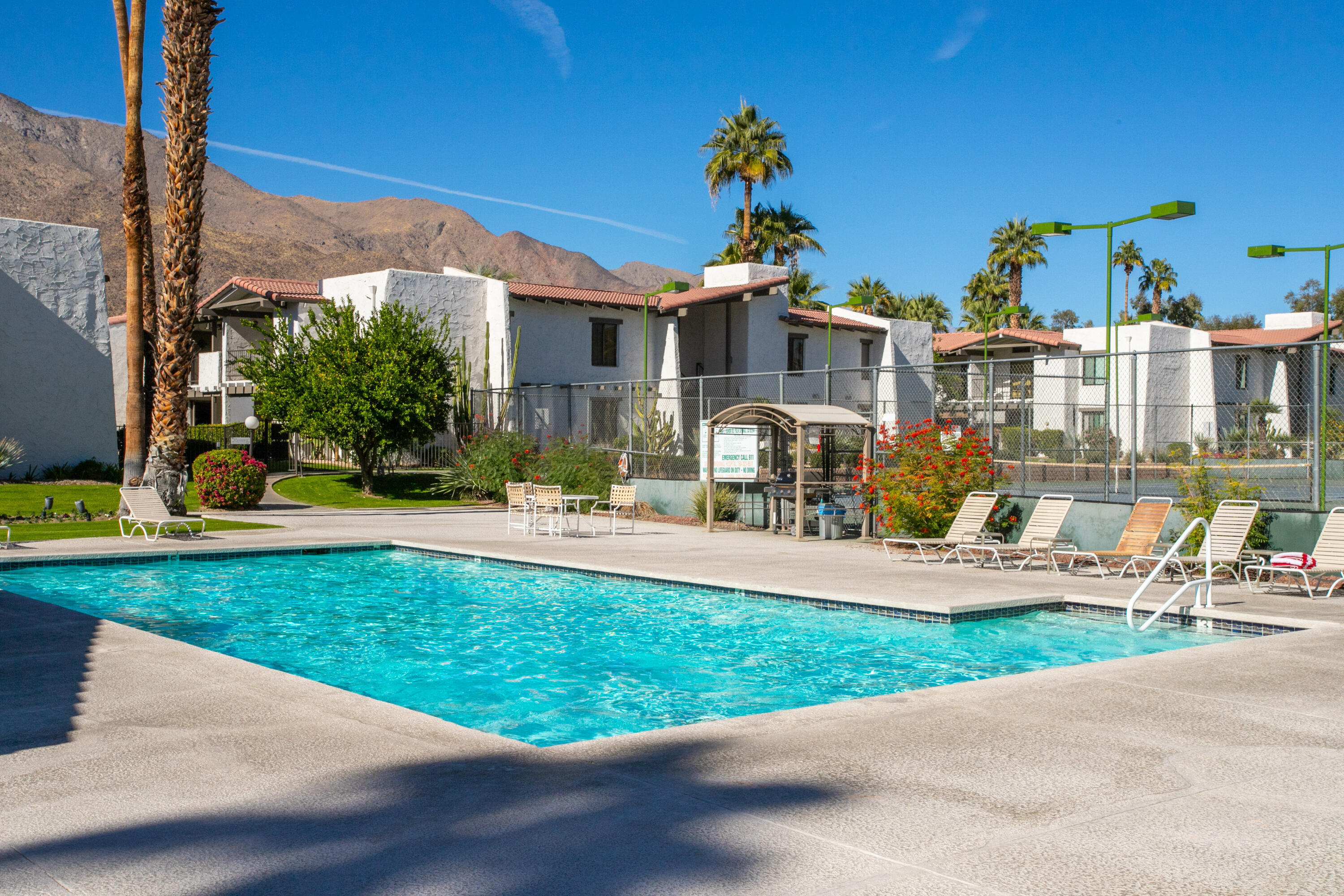 1050 Ramon Road, Unit 128 Palm Springs, CA 92264 - Photo 31 of 35 a front view of a house with garden and sitting area