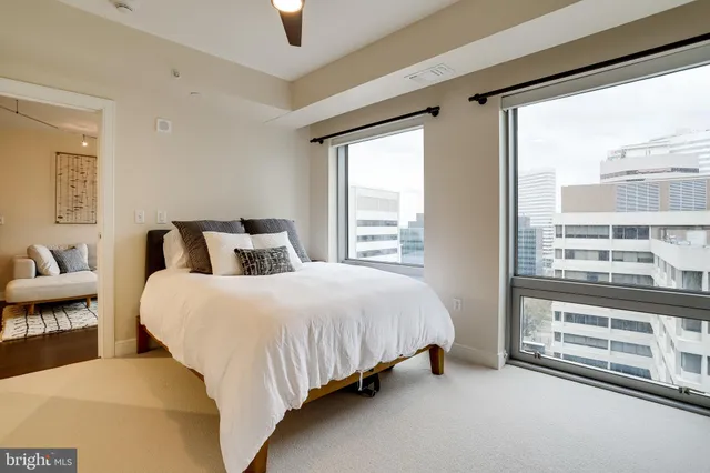 a bedroom with a bed and a large window