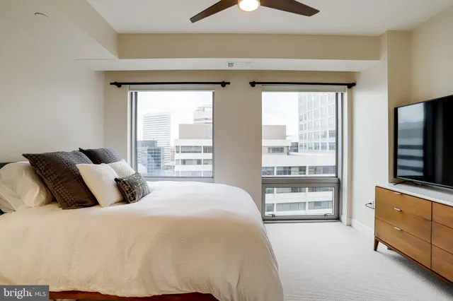 a bedroom with a large bed and a flat tv screen on dresser