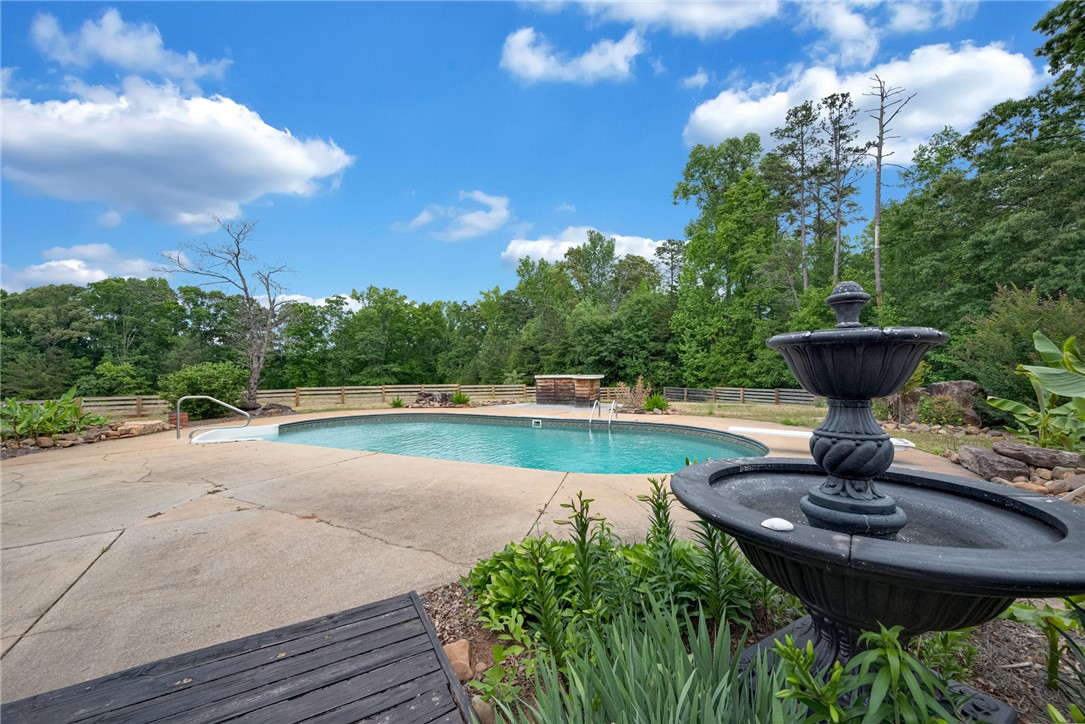 433 Latham Road Easley, SC 29640 - Photo 45 of 50 An inviting outdoor pool with a decorative fountain offers a serene backyard escape.