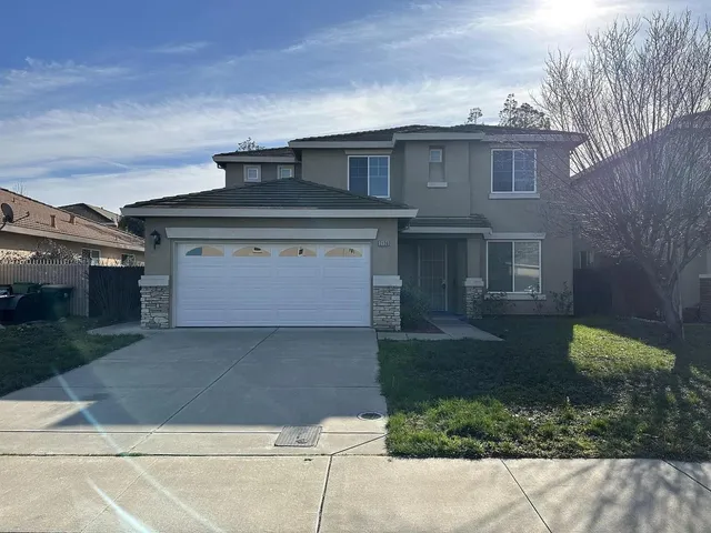 a front view of a house with a yard and garage