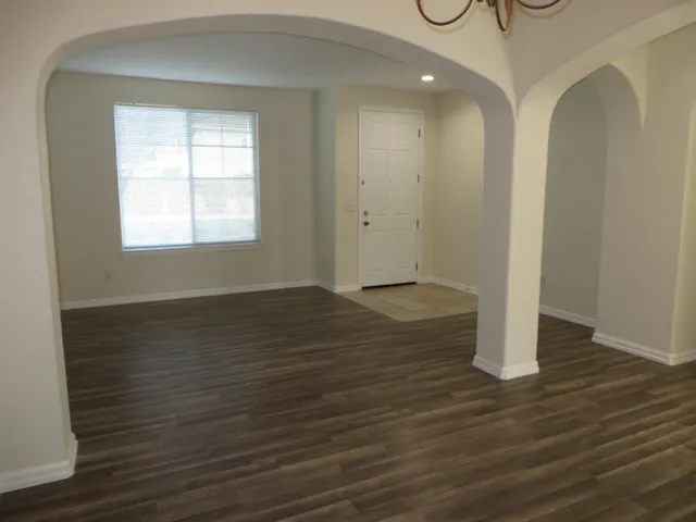 an empty room with wooden floor and window