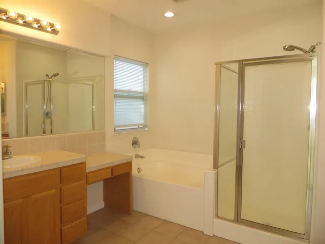 a bathroom with a tub sink shower and a mirror