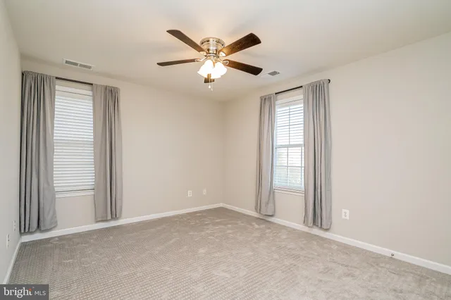a view of an empty room with a ceiling fan
