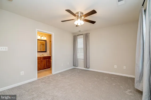 an empty room with closet and a chandelier fan