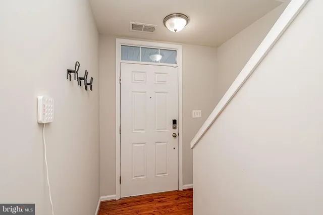 a view of a hallway with wooden floor and staircase