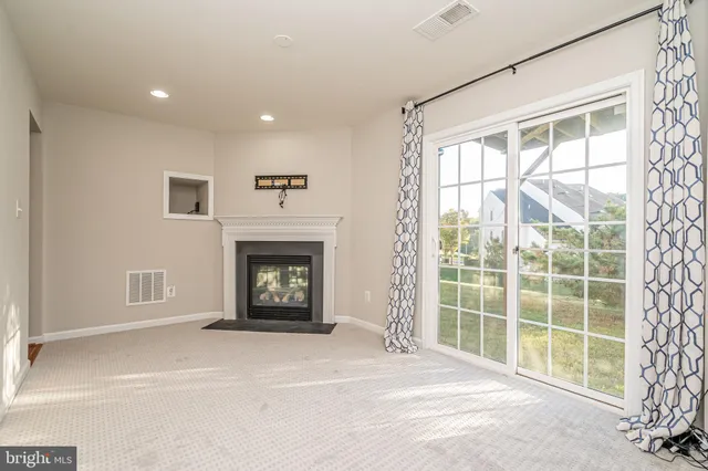 a view of a livingroom with a fireplace and a window