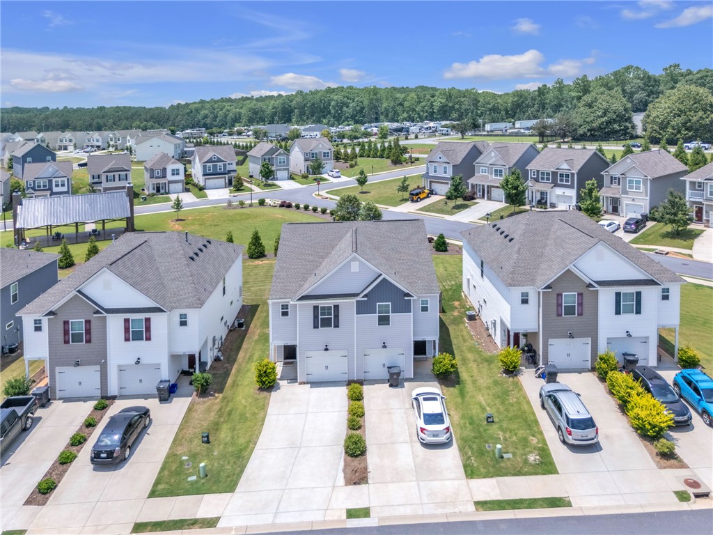 208 Samuel Street Pendleton, SC 29670 - Photo 28 of 32 An aerial perspective reveals a vibrant community of homes, each boasting a driveway and manicured lawn.